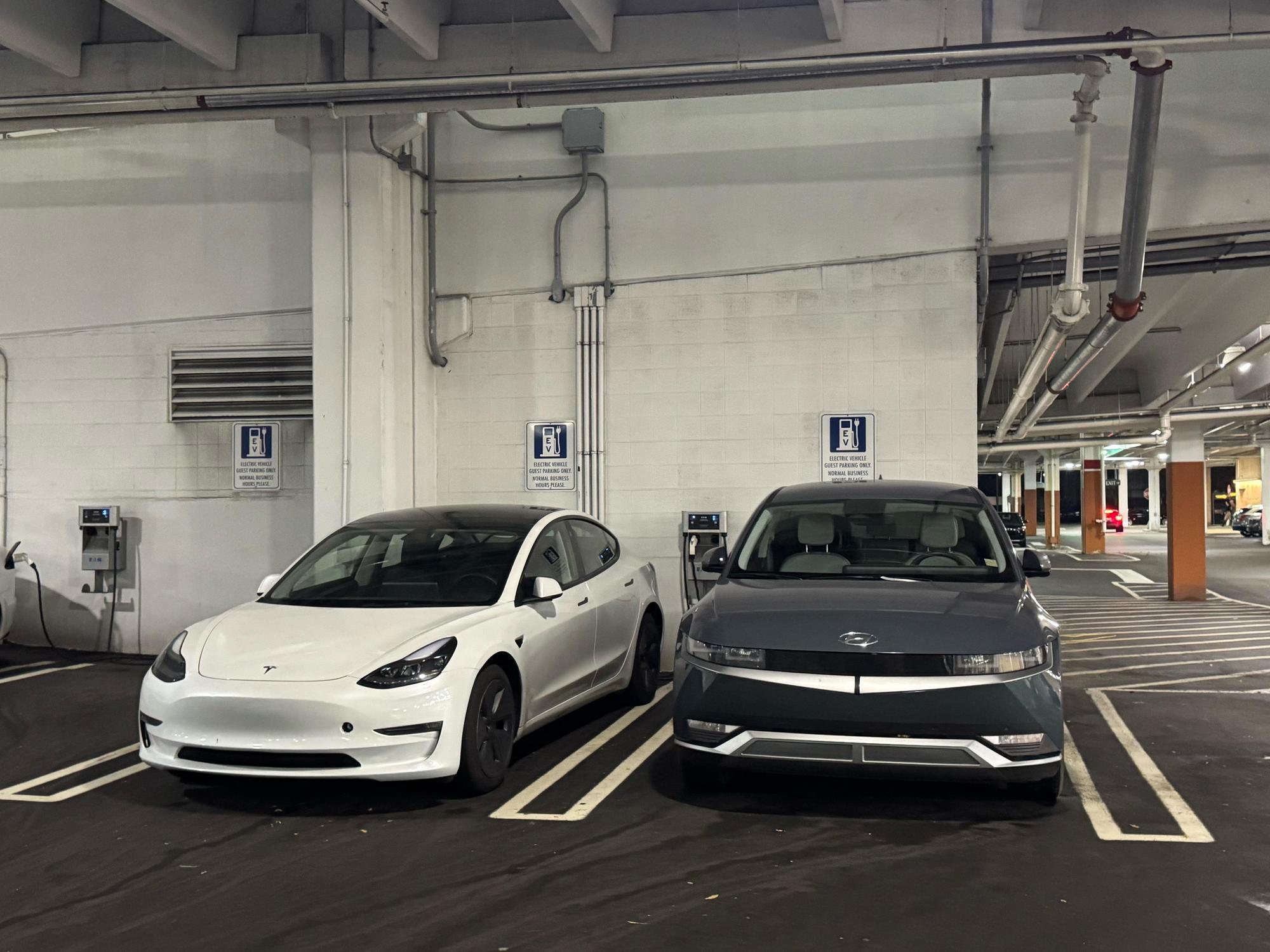 Level 2 charging stations in the Somerset Collection parking garage — Tesla and Hyundai charging side by side